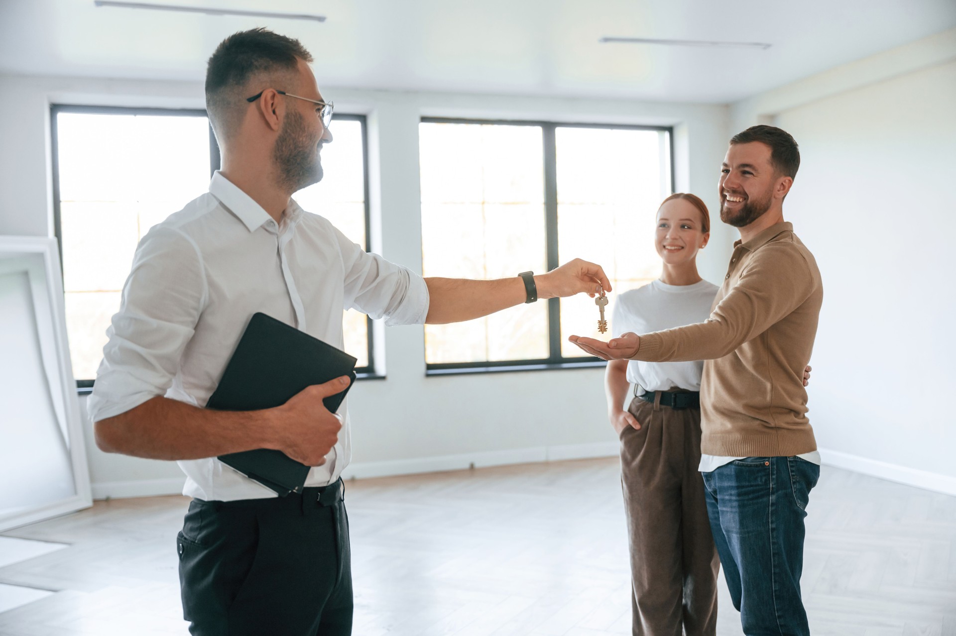 Giving the keys. real estate agent shows an apartment to a young couple